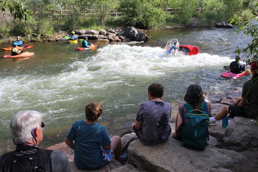 Spectators watch kayakers compete in the annual Kayak Rode June 22 at Clear Creek Whitewater Park.
